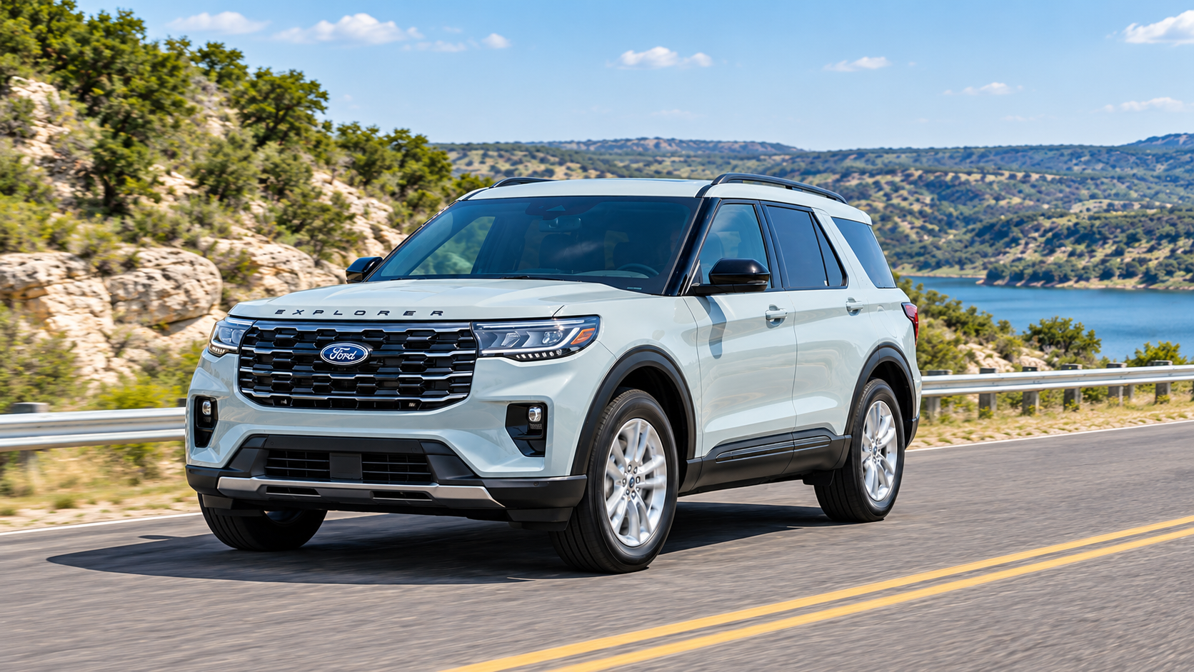 A light blue Ford Explorer SUV driving along a scenic highway next to a lake and hills.