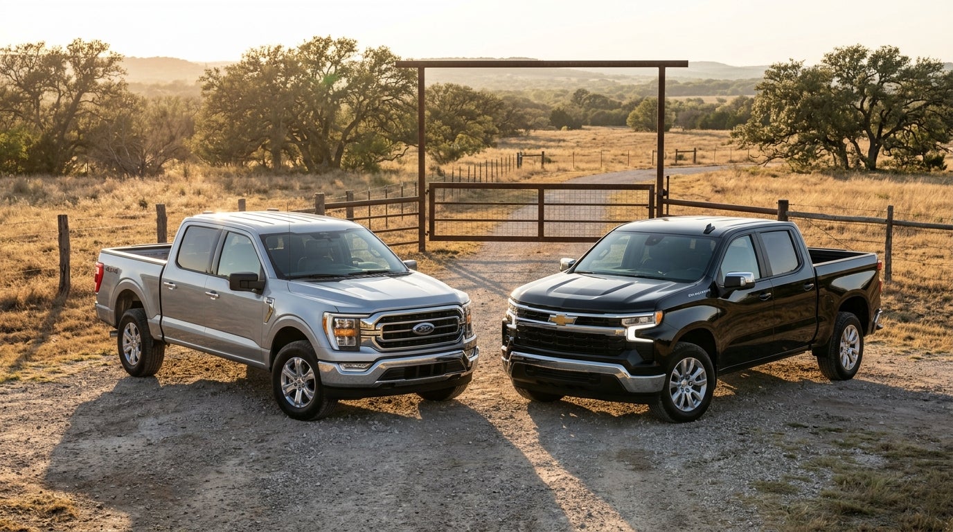 A silver Ford F-150 and a black Chevrolet Silverado parked side-by-side on a dirt road near a ranch gate. (Representative image for illustration purposes only. Actual vehicle may vary based on trim and configuration.)